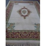 A fringed woolen carpet on cream ground with central medallion and borders.