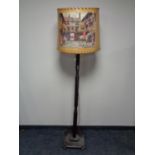 An early 20th century standard lamp with shade depicting a hunting scene.