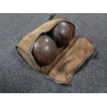 A pair of vintage wooden lawn bowls in a cloth bag.