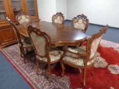 An Italian style shaped twin pedestal dining table with six chairs, two carvers and four singles.