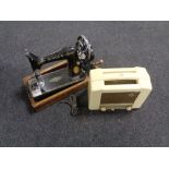 A vintage Singer hand sewing machine together with a cream Bakelite cased Ekco radio.