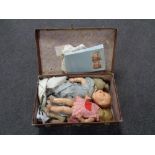 A mid 20th century luggage case containing plastic and cloth dolls, doll's clothes.