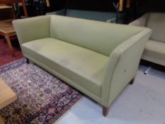 A 20th century continental settee upholstered in a green fabric.