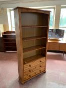 A set of pine open bookshelves fitted three drawers beneath