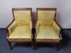 A pair of early 20th century inlaid mahogany armchairs upholstered in a gold classical fabric.