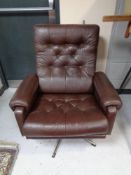A 20th century brown button leather swivel armchair on chrome base.