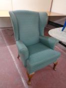 A Parker Knoll wingback armchair upholstered in a green Art Deco fabric