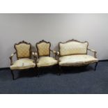 A three piece carved beech framed French style salon suite upholstered in a gold fabric.