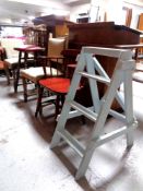 A bar chair together with a pair of blond oak dining chairs,