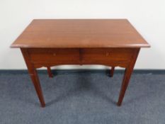 An early 20th century two drawer side table on raised legs.