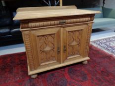 A 20th century continental oak double door low sideboard with carved panel doors,