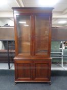 A 19th century mahogany double door glazed bookcase, fitted cupboards beneath.