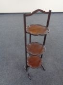 An Edwardian mahogany three tier pie crust edge folding cake stand.