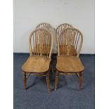 A set of four elm wheelback dining chairs.