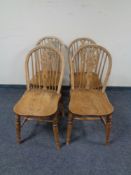 A set of four elm wheelback dining chairs.
