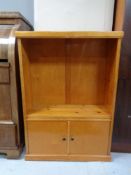 A set of 20th century pine open bookshelves, fitted cupboards beneath.
