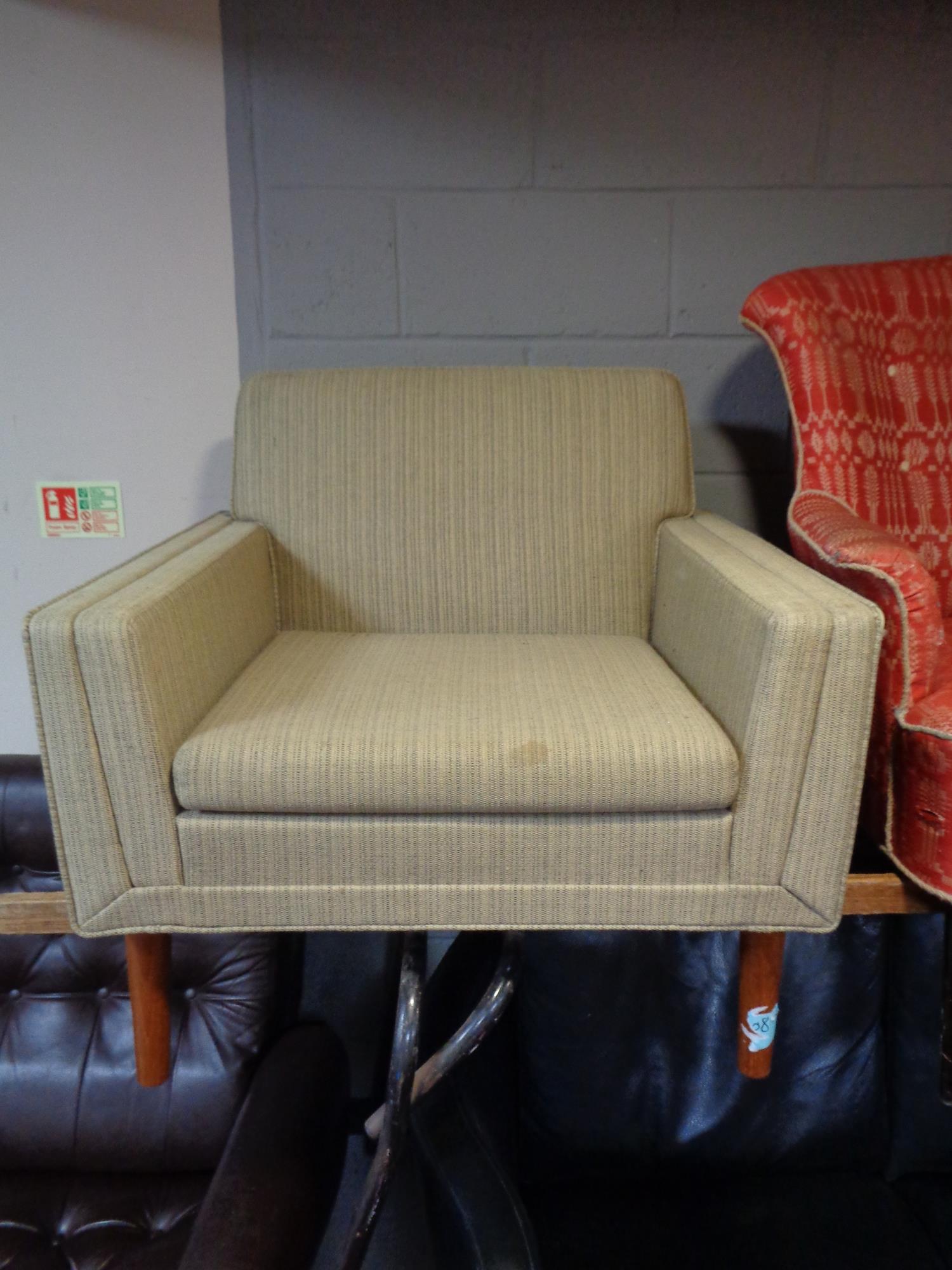 A mid 20th century armchair on teak legs.