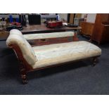 A late 19th century carved oak framed chaise longue upholstered in a striped Regency style fabric.