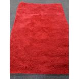 A contemporary red shaggy pile rug.