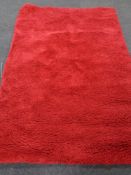 A contemporary red shaggy pile rug.