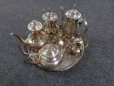 A silver plated twin handled tray containing six pieces of plated tea ware