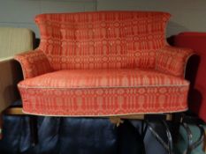 A 20th century shaped back settee upholstered in a red and silver fabric.