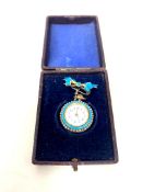 A lady's silver and enamel fob watch with bow brooch in case.