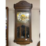 A 20th century oak cased wall clock with brass and silver dial.