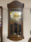 A 20th century oak cased wall clock with brass and silver dial.