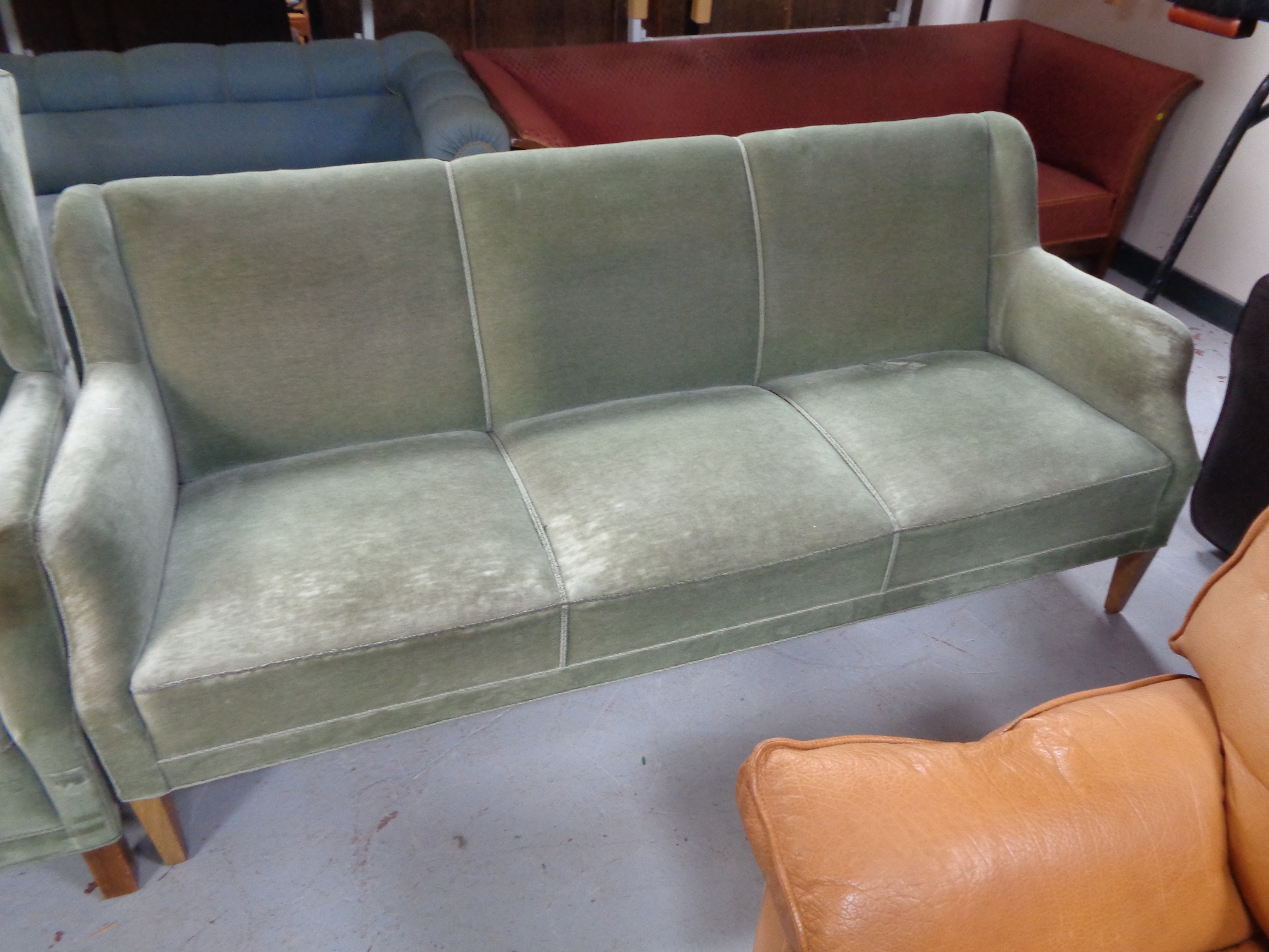 A 20th century three seater settee upholstered in a green dralon.