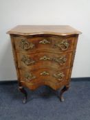 A 19th century serpentine fronted French walnut three drawer chest with ormolu mounts and handles