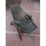 A wooden slatted garden lounger chair