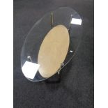 A contemporary oval glass topped coffee table.