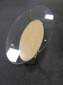 A contemporary oval glass topped coffee table.
