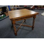 An Edwardian oak barley twist pull out dining table.