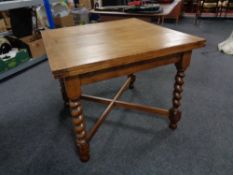 An Edwardian oak barley twist pull out dining table.