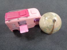 A Barbie mobile home together with a globe on stand