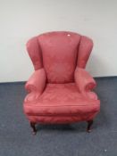 A Chapman's Siesta Victorian style wingback armchair upholstered in a red fabric.