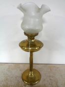 A brass oil lamp with glass shade