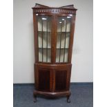 An Edwardian mahogany double door corner display cabinet, fitted cupboards below,