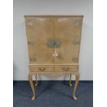 A 20th century figured walnut double door cocktail cabinet, fitted two drawers,