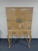 A 20th century figured walnut double door cocktail cabinet, fitted two drawers,