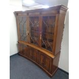 A Regency style mahogany triple door concave bookcase, fitted cupboards below.