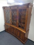 A Regency style mahogany triple door concave bookcase, fitted cupboards below.