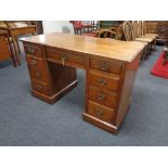 A 19th century walnut kneehole desk, fitted nine drawers, with brass drop handles.