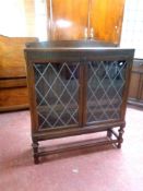 An early 20th century oak double door bookcase with leaded glass doors