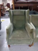 A 20th century wingback armchair upholstered in a green dralon.