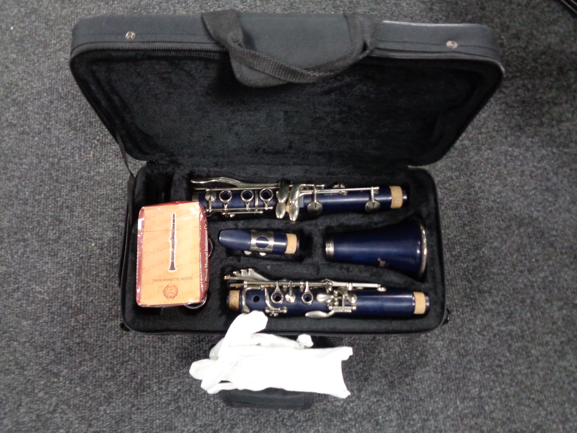 A four piece Slade clarinet in case with reeds and gloves