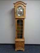 A Tempus Fugit blonde oak longcase clock with pendulum and weights.