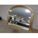 A contemporary gilt framed arch topped overmantel mirror.